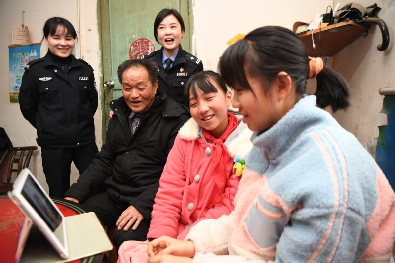 2月7日，杨佳鑫（右一）和杨思怡（右二）在湖南常德津市同乐堡村家中通过志愿者的平板电脑和在广西打工的父亲视频通话。（新华社照片）