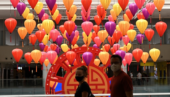 People walking past colorful lanterns inside a shopping mall in Singapore to usher in the Lunar New Year. AFP