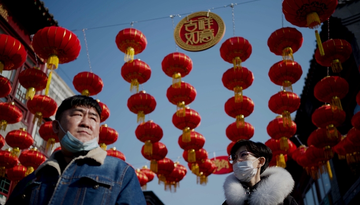 People walking under traditional Chinese lanterns along an alley in Beijing ahead of the Lunar New Year. AFP