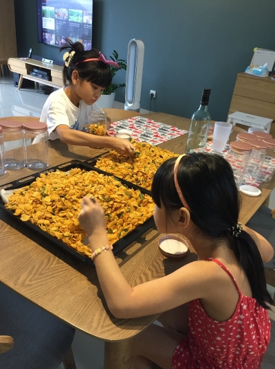 两名8岁及11岁的女儿都会参与年饼制作， 帮忙妈妈林佩嫣将年饼整理入盒、美化包装、写便条寄语，从中感受新年的气氛。