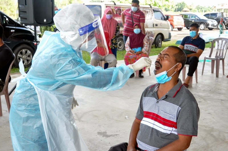 卫生部人员为甘榜达绕居民进行冠病检测。（马新社照片）