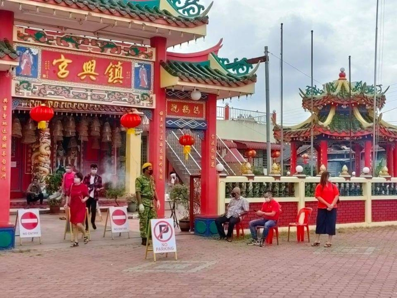哥市唐人坡妈祖庙安排志愿警卫团在庙口控制进庙的善信人数。

