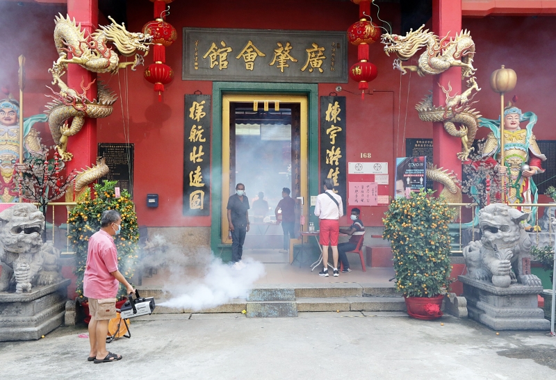 吉隆坡茨厂街关帝庙人潮稀疏，工作人员在庙口喷雾消毒。

