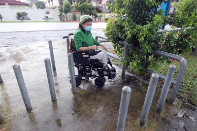 大马残障自立协会附近有社区公园，其入口处是一个无障碍设计，谢秀贞向记者示范如何顺利地走过“S”入口。