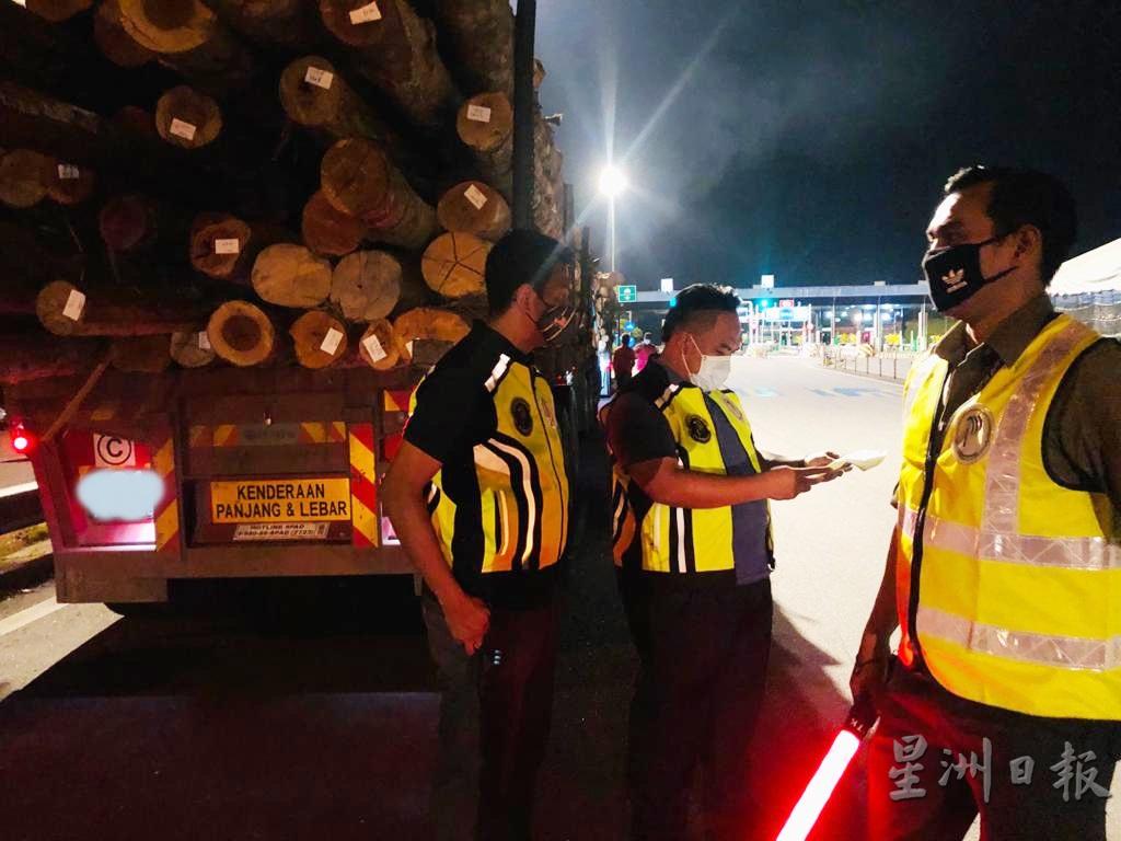 年柑取缔行动在白天与夜晚时刻进行，执法人员正在调查一辆运载木材的罗里。
