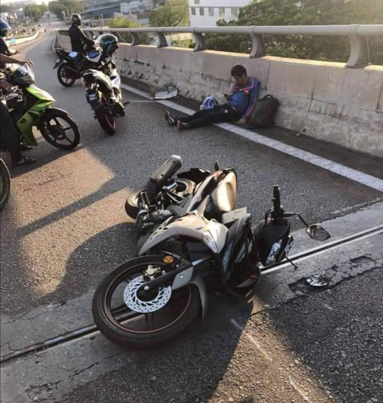 摩托车被逆驶车辆撞倒，受伤的骑士躺坐地上。