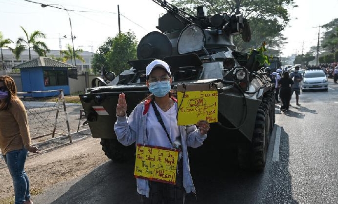 A protester standing next to military vehicles parked along a street in downtown Yangon. AFP A protester standing next to military vehicles parked along a street in downtown Yangon. AFP