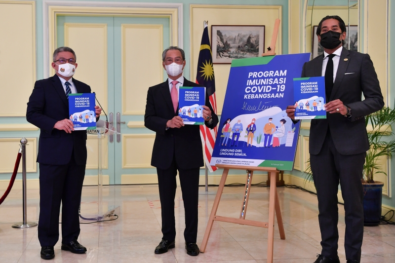 慕尤丁（中）在凯里（右）和阿汉峇峇的陪同下，共同为全国疫苗接种计划指南主持推介礼。