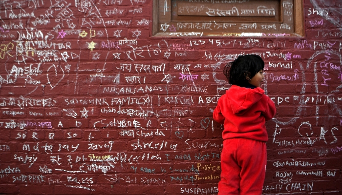 People writing messages with chalk on a wall at the Saraswati Temple  in Kathmandu, Nepal, on the occasion of the Hindu festival of 'Basanta Panchami'. AFP