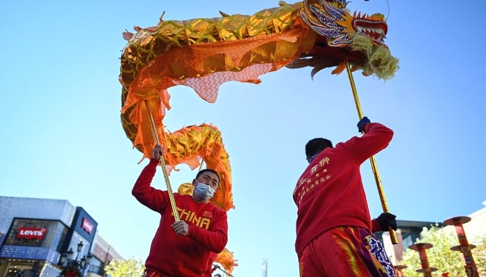 Members of a dragon dance troupe perform outside a mall in Beijing on the fifth day of Lunar New Year. AFP