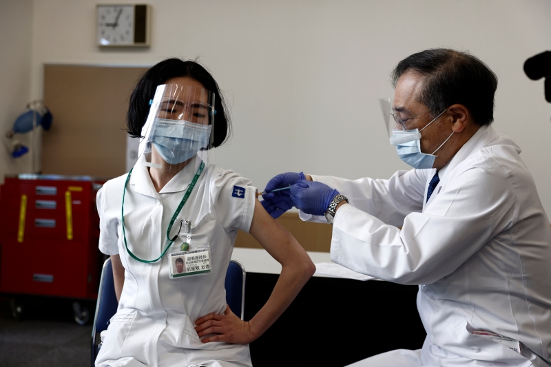 日本周三启动冠病疫苗接种计划，图为在东京医疗中心，一名医护人员接种疫苗。（图：美联社）