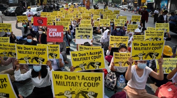 Protesters hold up signs during a demonstration against the military coup in Yangon. AFP Protesters hold up signs during a demonstration against the military coup in Yangon. AFP