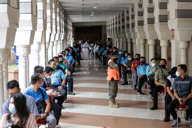 印尼当局周三开始为雅加达塔纳阿邦成衣批发市场的商家及零售员接种疫苖。图为商贩与店员耐心等候接种。（图:欧新社）