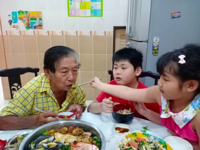 孙女喂冯亚忠（左）吃东西，让公公甜在心。