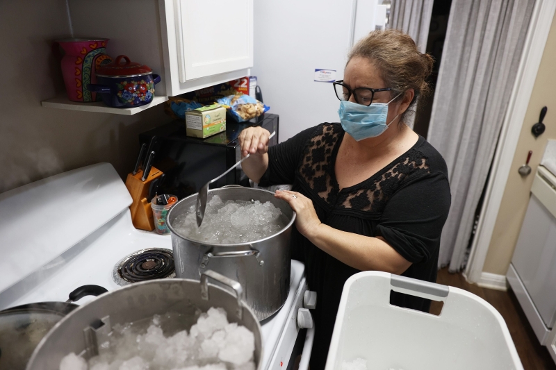 因缺水，得州首府奥斯丁一位女居民将冰雪煮溶后，用来冲洗马桶。（法新社照片）