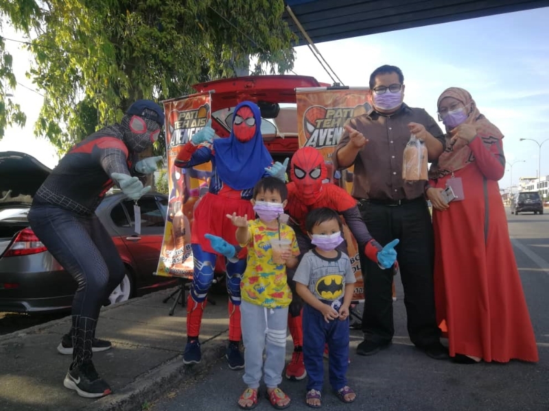 复仇者联盟冰奶茶热卖。顾客买奶茶后和包括蜘蛛女侠（左二）在内的超级英雄合照。