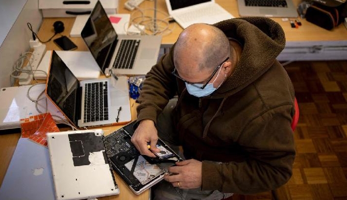 A Catbytes team member repairing a donated computer at Ewart Community Hall in south London. AFP