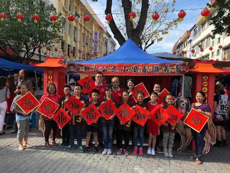 张少纶（后排左）与参与加雅街市集挥春的学生们一起展示“福”字斗方。