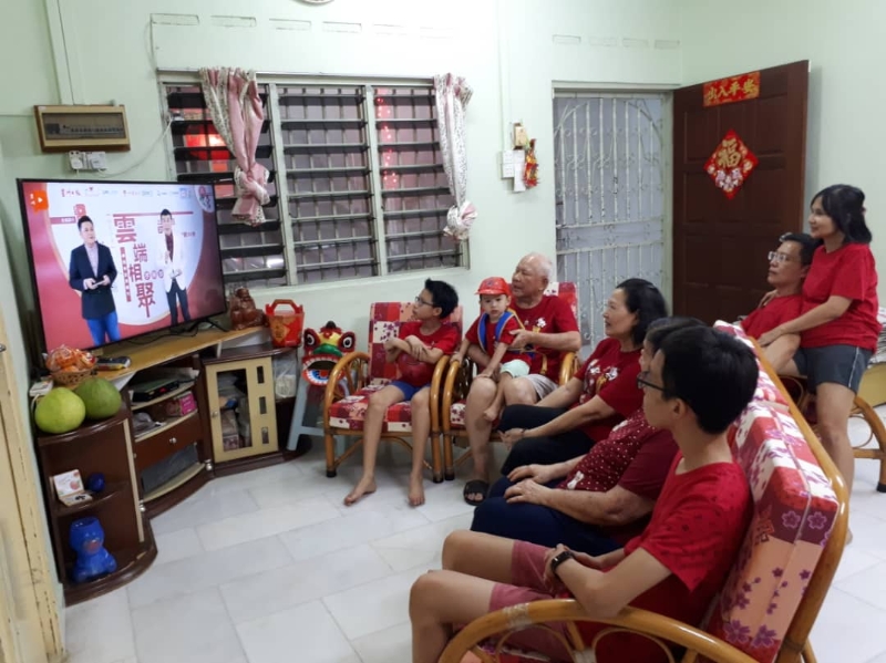 全家打穿上红衣服，欣赏星洲百格准备的特别节目。
