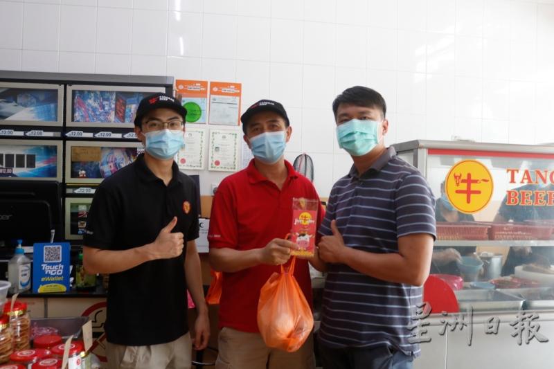 适逢牛年推出红包套，韩家定（左起）和韩伟畴赠送给上门外带的常客温思安。
