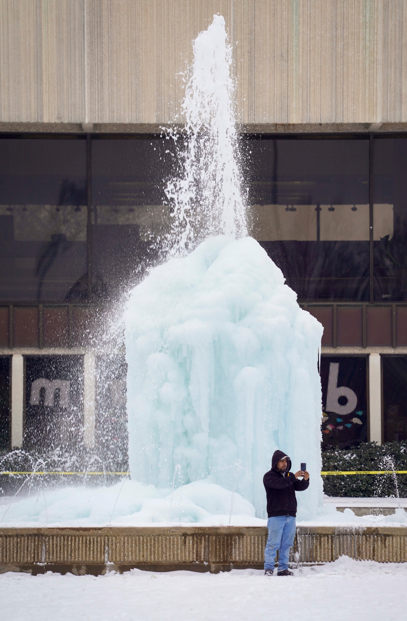在得州北部的理查森市民中心，一座喷泉冻结成冰，吸引了民众前来自拍打卡。（美联社照片）