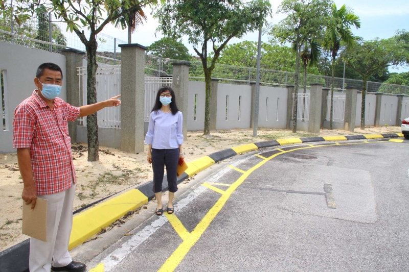 余保凭（左）及侯小姐指出，甲洞富城园Areca Residence二度重建和加高的围墙，让居民感觉好似坐牢。