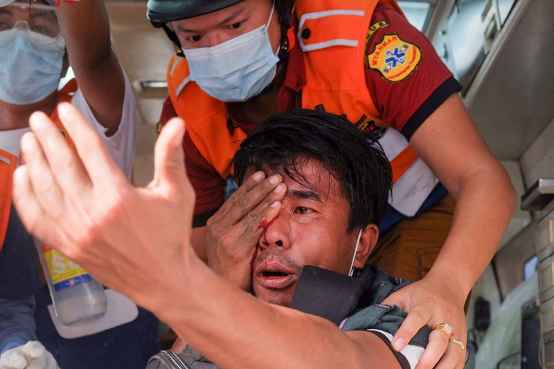 医护人员救治一名被安全部队发射的弹弓击中眼部的男子。（图：法新社）