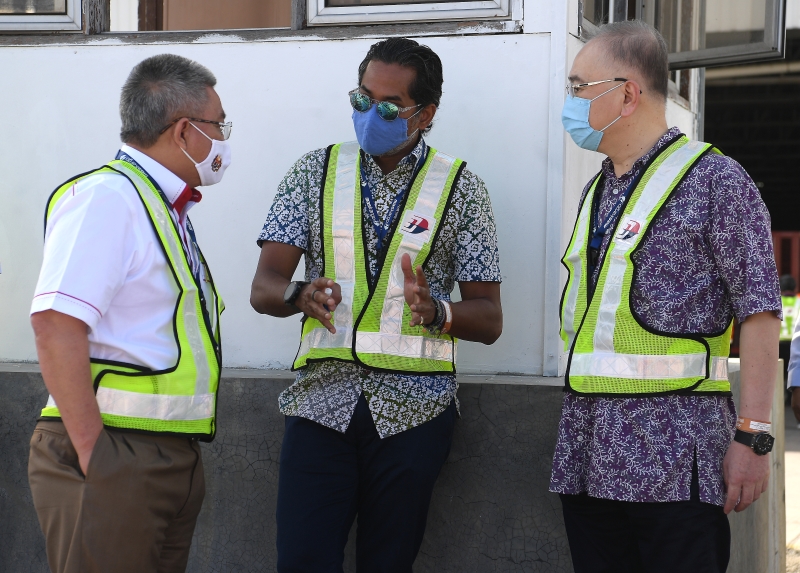 卫生部长拿督斯里阿汉峇峇（左起）、科学、工艺及革新部长凯里以及交通部长拿督斯里魏家祥在机场进行协调及讨论，确保接受及运送疫苗的过程顺利。（图：马新社）