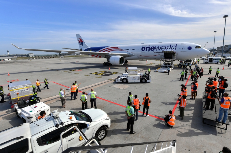 机场工作人员从飞机将疫苗运到物流公司的罗里。（图：马新社）