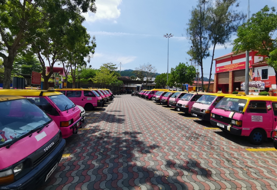 邦咯岛上的粉红德士无客可载，停满在码头外的泊车位上。