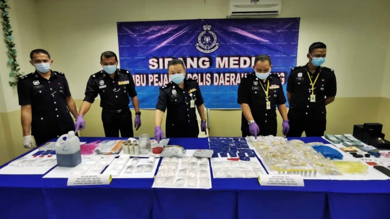 张明广（中）展示警方在行动中起获的毒品。左二为莫哈末再因。