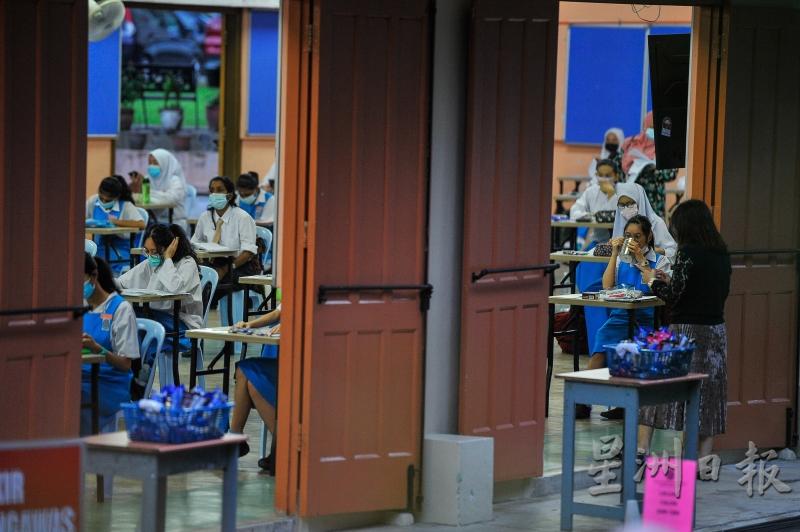 参加2020年大马教育文凭考试的应考生遵守标准作业程序，在吉隆坡咖啡山姑娘堂教会中学考场内佩戴口罩。