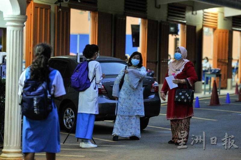 教师在吉隆坡咖啡山姑娘堂教会中学内，检查2020年大马教育文凭应考生的健康状况，以及确保应考生都有遵守防疫标准作业程序。