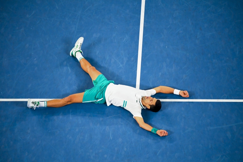 佐科维治夺冠后舒畅地躺在澳网中央球场，说了声：“我每一年都会越来越爱这个球场。”（欧新社照片）
