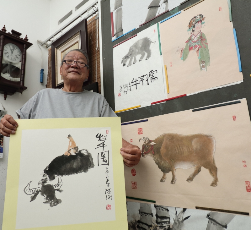 黎潮湘手握“水中牛”的画作。