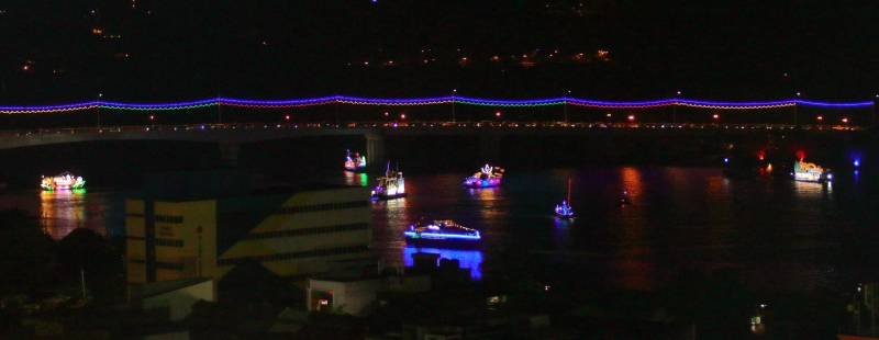 数艘花船在丹绒弄坡大桥下游行。