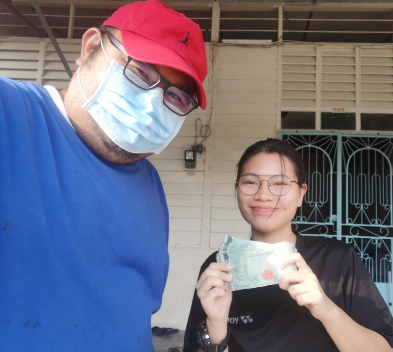 星洲日报高级记者陈世传（左）把善心读者的捐款，送到郑莉莉的手中。

