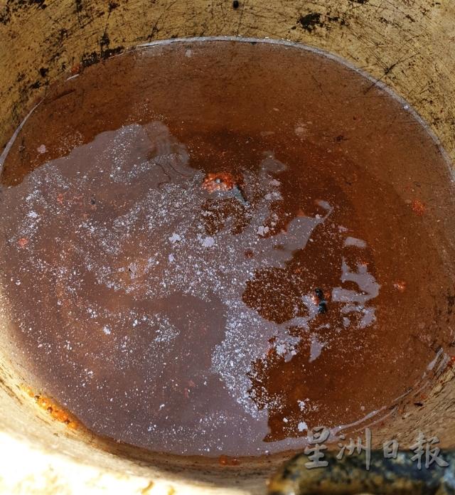 从井中打捞上来的井水浑浊，表面上还漂浮一层油渍。