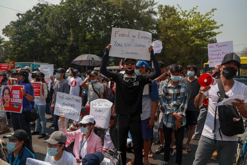 示威者来到印尼大使馆外高喊口号，以及高举写着“是友是敌？由你选择，印尼”纸板标语。（图：美联社）