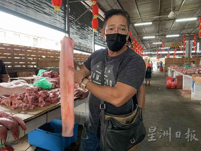 猪肉贩展示猪皮表面的印章，证实猪肉已经通过兽医局安全检验。