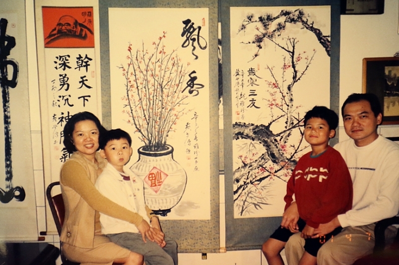 魏雅珍（左一）和家人在黄世传的家中，于其作品前合照。右起是先生陈学全、大儿子陈立恒、二儿子陈立杰。