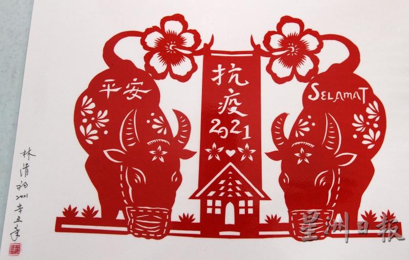这幅平安剪纸是林清福的2021年剪纸主题，两头对称的牛儿戴口罩稳居草地左右，牛尾巴有一对大红花串联，深具本土赤道风情和中华文化色彩。

