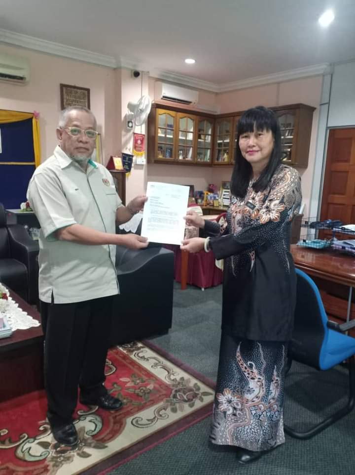 颜玉妹从淡马鲁教育局局长旺哈密手中接领调职信函。