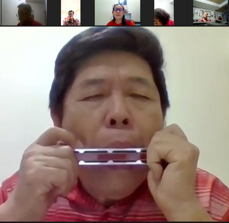 和声音乐协会主席梁广成通过Zoom线上视频给会员带来口琴表演。