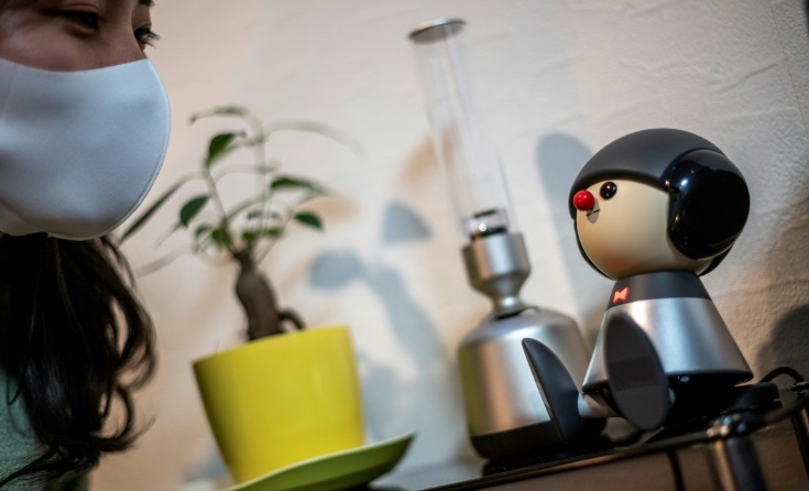 Nami Hamaura says she feels less lonely working from home thanks to her singing companion Charlie, a Japanese robot. AFP