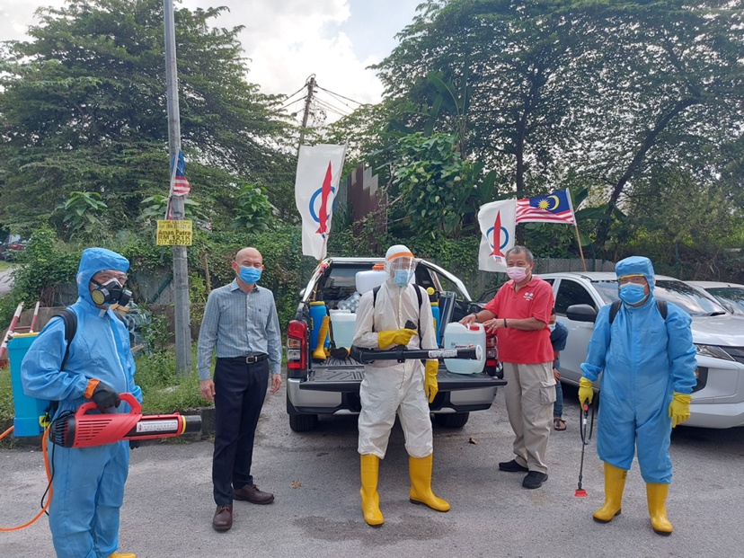 甲洞国会议员林立迎（左二）带领消毒队前往有需要的地区进行消毒工作。