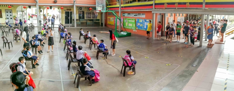 芙蓉培华小学放学时段，学生会被安排在篮球场，家长就被安排在球场旁的食堂范围，陆续接孩子回家。