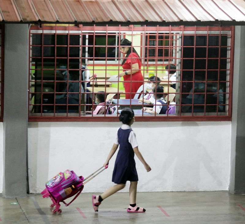 由于家长不被允许进入校园，孩子只能自行拖着书包去上课。