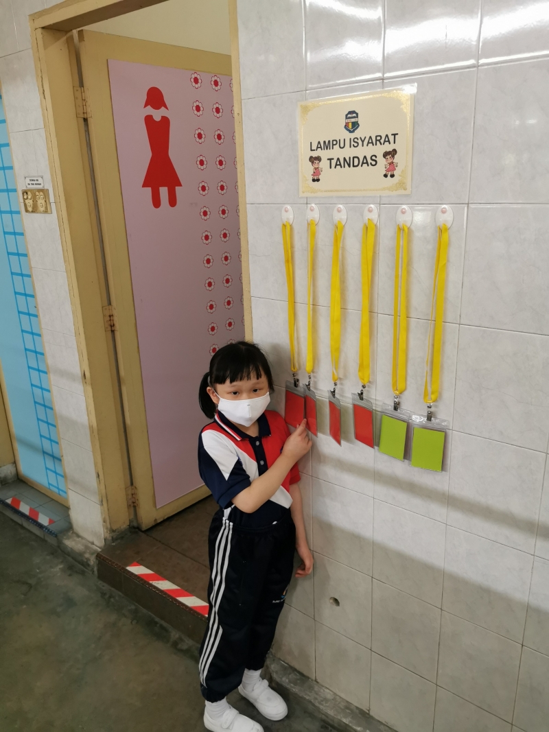 爱群一校的“厕所红绿灯”，规定学生进入厕所时翻开红牌，每次只限6人同时使用厕所。