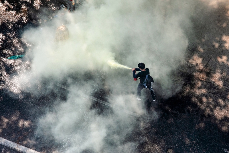 在仰光，一名示威者拿灭火器警察喷。（法新社照片）
